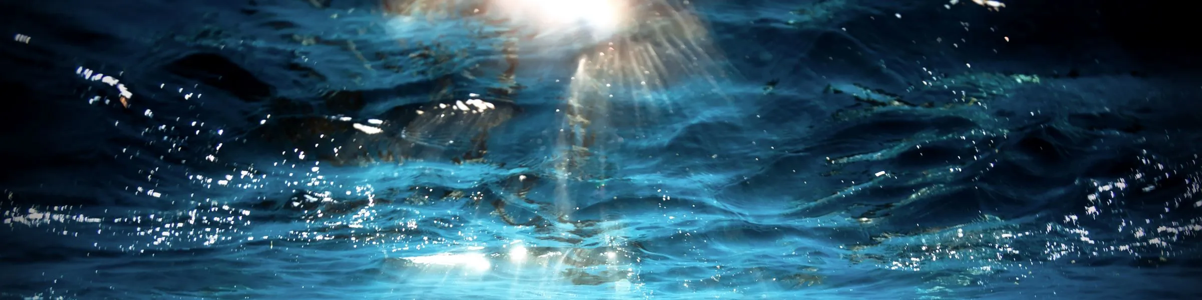 Sunlight filtering through blue ocean water, creating shimmering patterns.