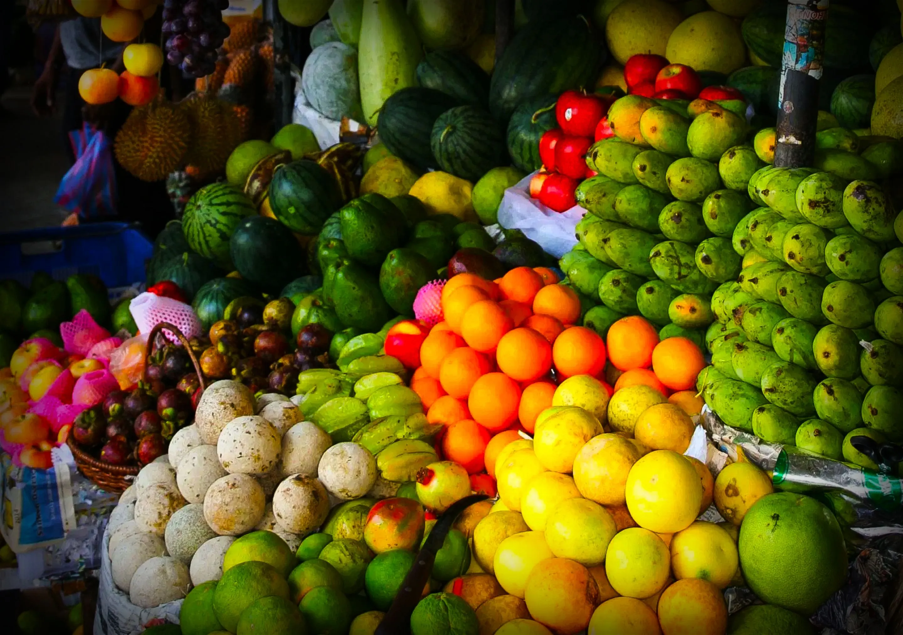 Assorted tropical fruits displayed at a market stall.
