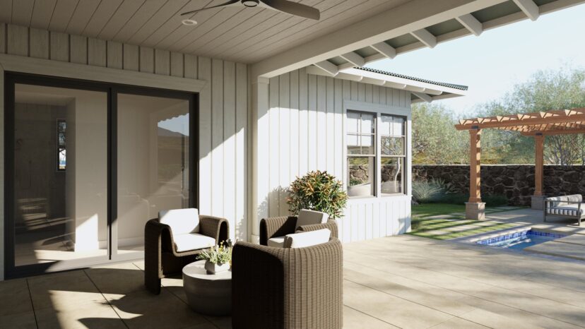 A patio with two wicker chairs and a round table. The area overlooks a small pool, a pergola, and a stone wall. The building features large windows and a ceiling fan.