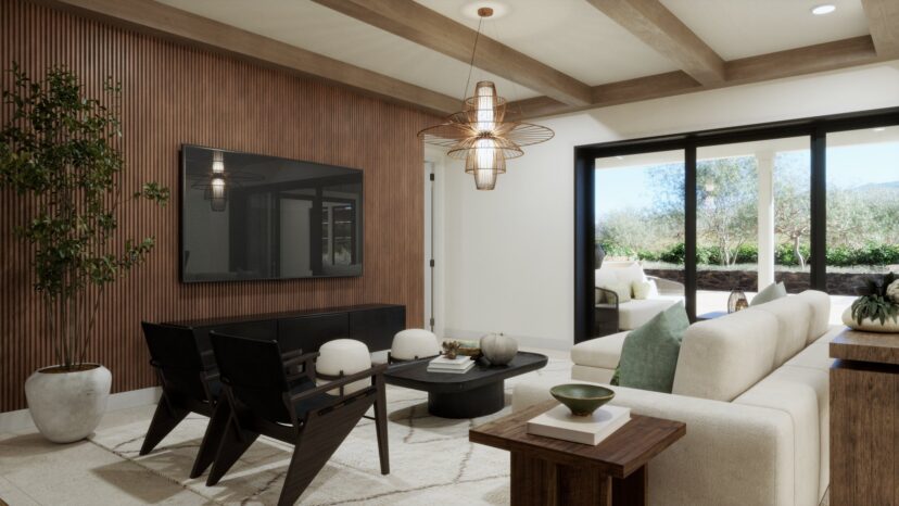 Modern living room with a large TV, cushioned sofa, two dark chairs, and a central coffee table. Glass doors open to a patio with outdoor seating and greenery. Neutral tones throughout.