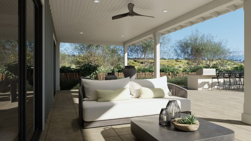 Modern outdoor patio with a sofa, cushions, and a coffee table with plants. Ceiling fan above. Scenic view of greenery and hills in the background.