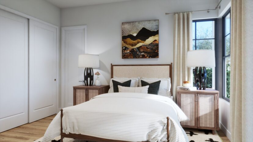 A bright bedroom with a bed, two wooden side tables with lamps, a landscape painting above the bed, and a window with beige curtains.