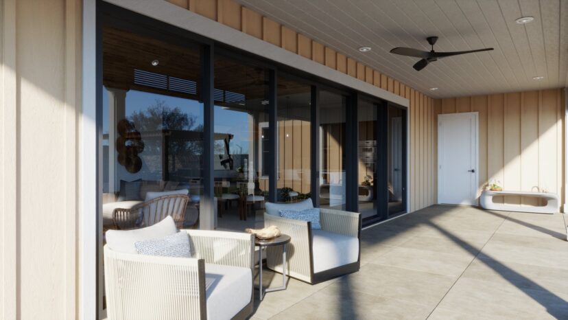 A modern patio with beige siding, large glass doors, two white cushioned chairs, a small table, ceiling fan, and outdoor seating visible inside.